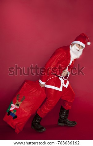 Disappointed Santa Claus pulls a bag stuffed with presents