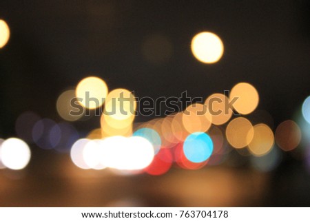 Abstract Light Bulb Defocused Background. Colorful White, Red, Yellow, Orange and Blue Glitter Festive Lights Reflection on Dark Bokeh Wallpaper. Blurred City Street at Night, Simple Scene Image.