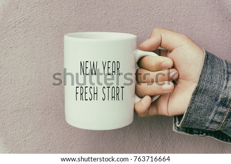 Hands Holding a Coffee Mug With Text New Year Fresh Start Royalty-Free Stock Photo #763716664