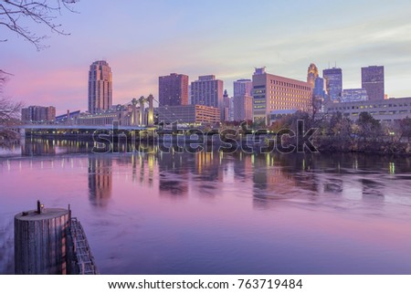 A Wide Angle Shot of the Hennepin Bridge and Downtown Minneapolis under a Pink Twilight Reflecting in the Mississippi River