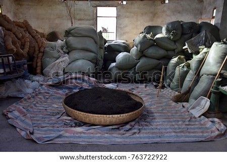 The bamboo basket brimfull of the black Chinese tea. Inside the tea factory.