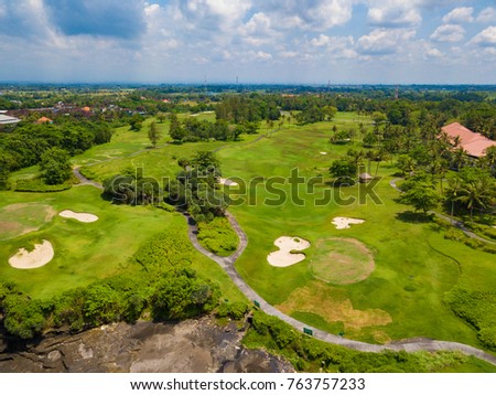 Aerial view to golf club with green hills and many palm trees near Tanah lot temple, Bali island, Indonesia.