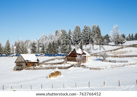 Wooden cottages in winter landscape