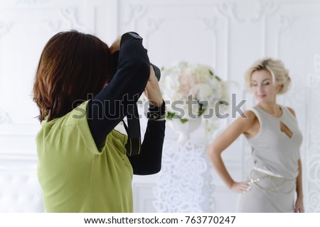 A female photographer takes a beautiful model in the studio.
