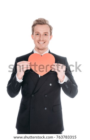 handsome stylish young man with red heart symbol smiling at camera isolated on white