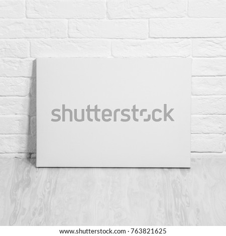 Mockup poster. White empty canvas. Brick wall on background.