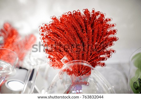 Stylish Christmas decoration elements consisting of glittering twigs covered with red sequins arranged in a bouquet