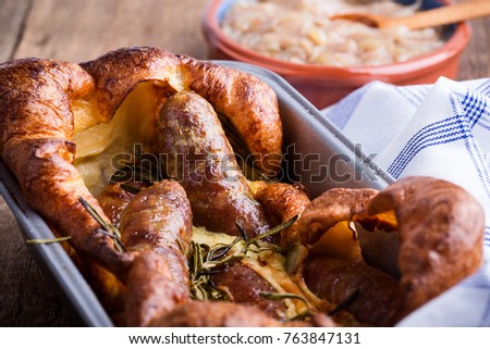 Baked sausages in Yorkshire pudding batter and served with  onion gravy, toad in the hole  