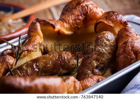 Baked sausages in Yorkshire pudding batter and served with  onion gravy, toad in the hole 
