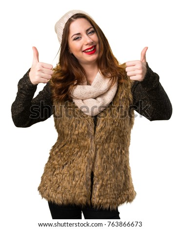 Girl with winter clothes with thumb up