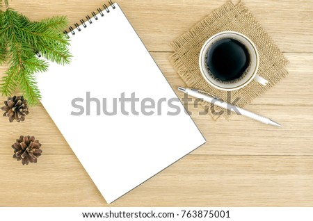 notebook, sheet of paper on a wooden table, coffee mug, spruce