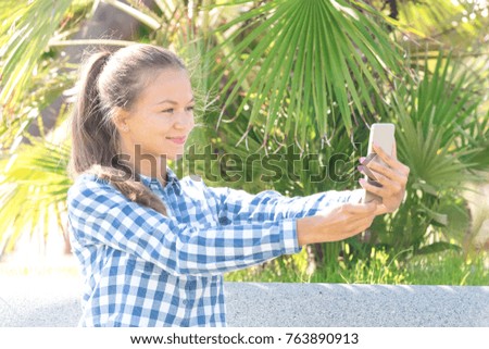 Young girl taking a selfie in a park