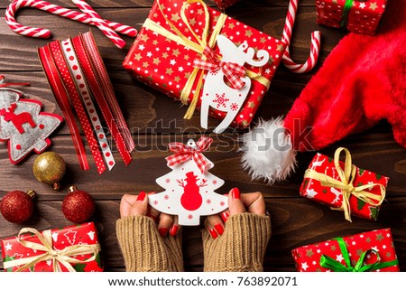 Woman holding Christmas decorations over wooden table