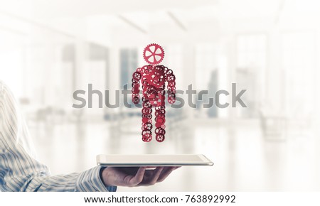 Close of businessman holdingn tablet pc with office worker figure. Mixed media