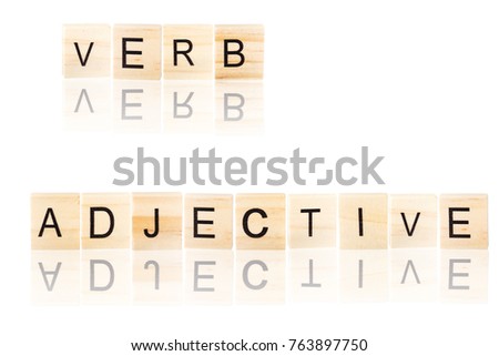 Black verb and adjective word with reflection, on wooden blocks on white isolated background.
