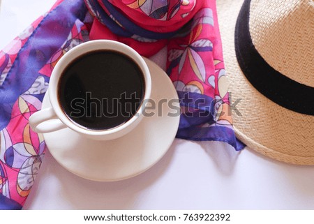 sea travel concept, black coffee on white cup and hat with scarf on white background.