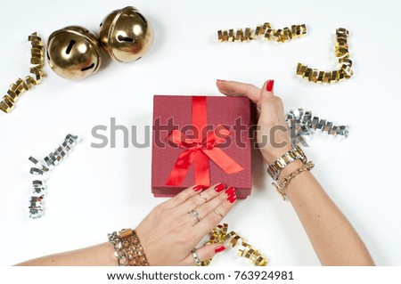 Christmas and New Year gift. Woman wearing bracelet. Christmas presents on a wooden table background