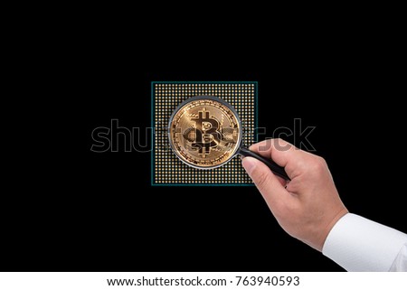 Bitcoins with magnifier on the black background