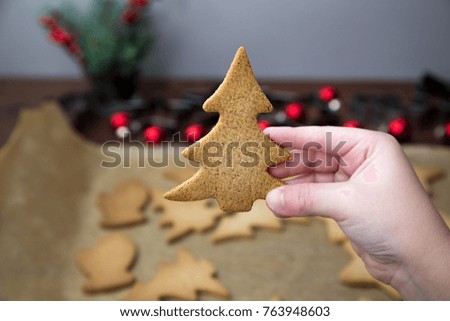 Boys hand holding a Christmas tree ginger cookie. A concept of a family Christmas activity.