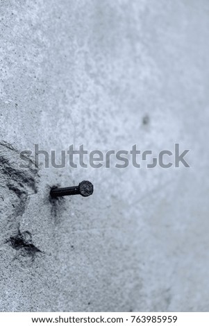 Cement pole with rusty nail, shallow depth of field
