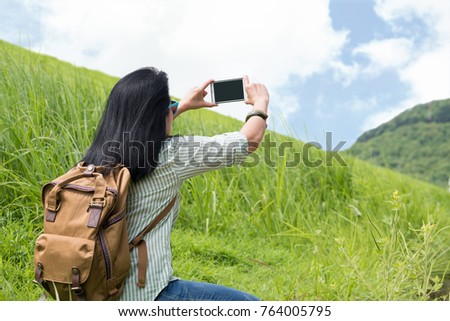 Asia woman traveler with backpack use mobile phone take a picture of landscape mountain view,Travel wanderlust concept