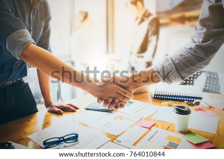 Image of Successful businessmen partnership handshaking after acquisition. Meeting for sign contracts and Group support concept. Royalty-Free Stock Photo #764010844