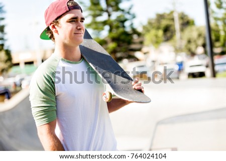 Teenage boy with skateboard standing outdoors