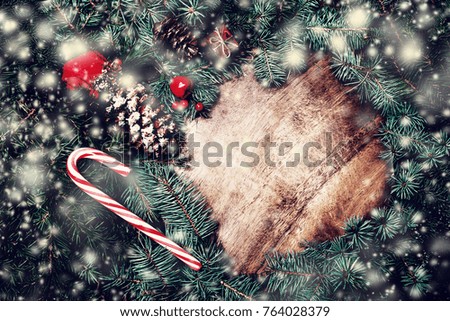 Christmas fir tree with decorations on dark wooden board, vintage holiday concept with copy space.
