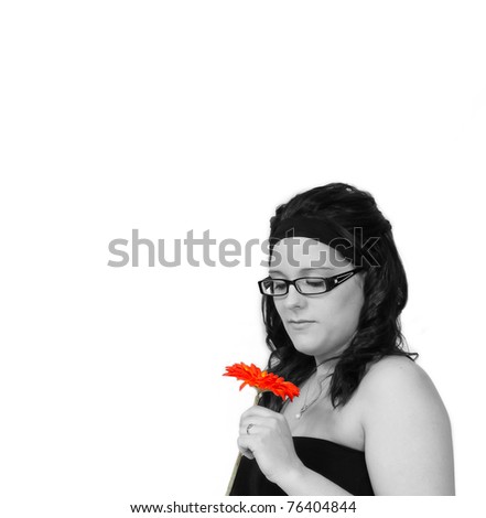 beautiful young woman smelling flower closeup in black and white with colored flower. isolated on white