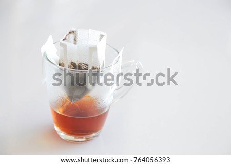A cup of tea with tea bag on white background