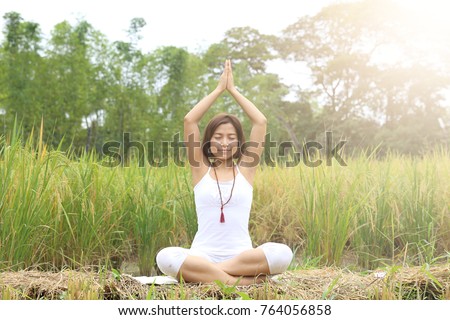 Healthy yoga lifestyle of Portrait of Asian young woman pose and practice yoga in organic rice paddy field. 