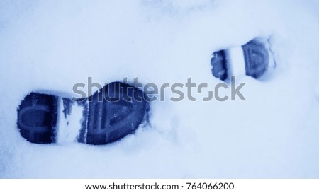 Dirty footprints in the snow in the winter. 