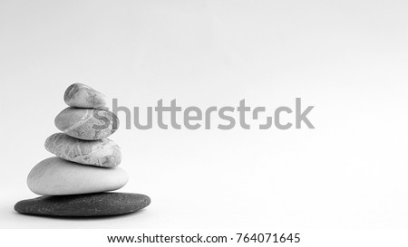 Balance of stones. Stones for spa treatments on a white background. The concept of meditation in the stones is stacked in pyramid.