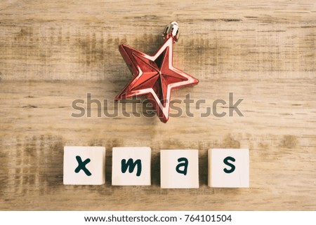 Xmas word on wooden block with Christmas ornament, retro style wooden background.