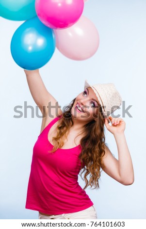 Woman charming girl playing with many colorful balloons. Summer, celebration happiness and lifestyle concept. Studio shot blue background