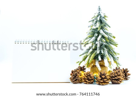 Christmas or New Year background with blank note pad,pine cones,gift box,golden ball and pine tree of Xmas decorations and fir branches, flat lay, blank space for a greeting text on white.