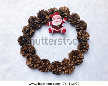 Christmas background concept with copy space for text design , santa claus sit inside the pine cone circle on soft blue background