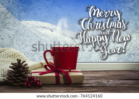 A beautiful image of a red cup and gift on a window sill with a beautiful winter landscape outside the window. Added text.
