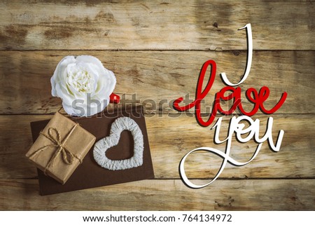 Gift box, heart of a handy and a white rose in a cup. The inscription I love you. Top view.