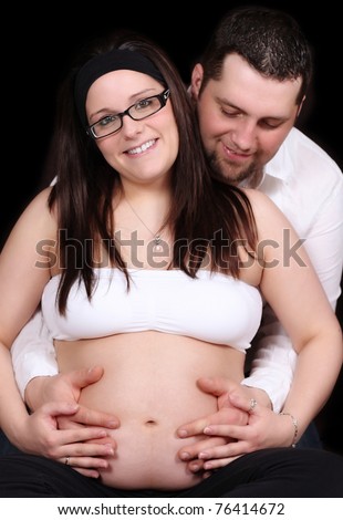 man holding pregnant wife and admiring her bare belly. isolated