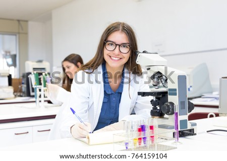 Beautiful young scientist working at the laboratory Royalty-Free Stock Photo #764159104