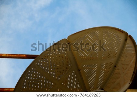 Old satellite dish and blue sky.