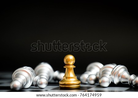 Gold pawn in chess game face with the another silver team on black background (Concept for company strategy, business victory or decision)