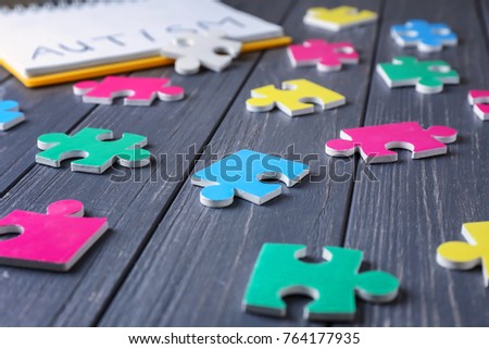 Different puzzles on wooden background. Concept of autism