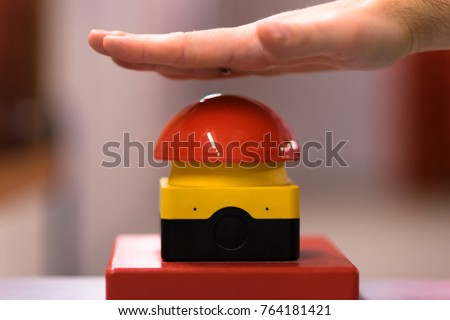 Hand above a red emergency button Royalty-Free Stock Photo #764181421