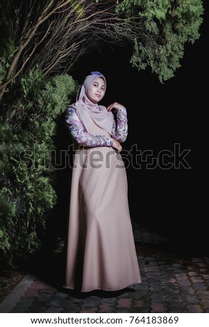 Portrait of beautiful  young asian muslim woman with hijab posing over dark background