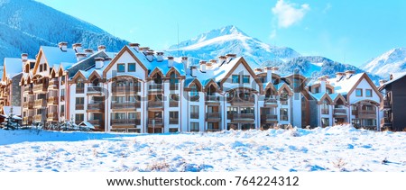 Wooden chalet, houses and snow mountains landscape and ski slopes panorama in bulgarian ski resort Bansko, Bulgaria Royalty-Free Stock Photo #764224312