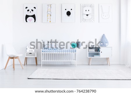White boy's bedroom with white furniture and animal posters on wall