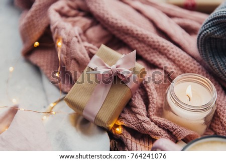 Christmas present with candle. Cozy winter concept. Still life at home