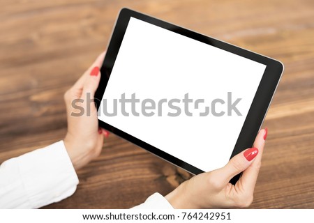 Woman holding tablet with empty white screen.